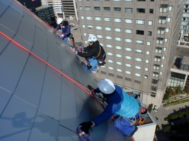 球体の上の部分はひざをついて拭き作業。渋谷の街の喧騒をBGMに一枚一枚拭き上げていきます。